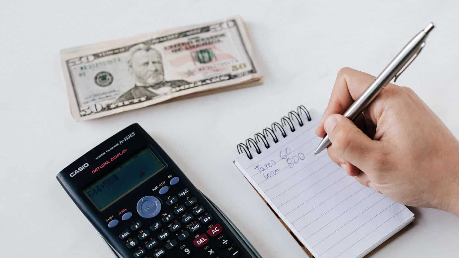 Calculator, cash, notebook on white background