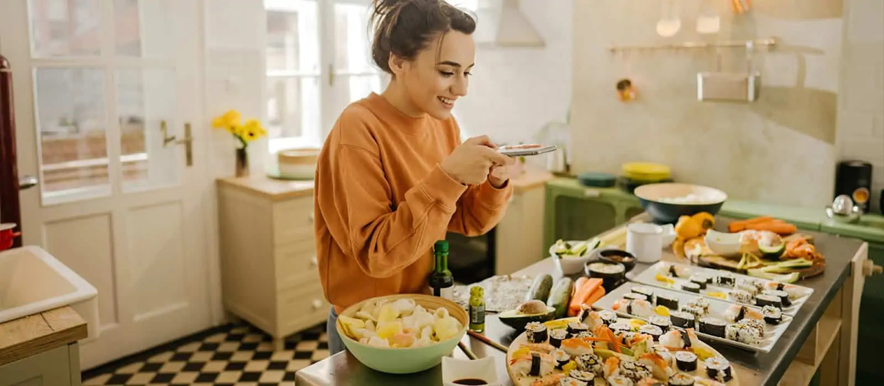 Woman taking photo of plates of sushi