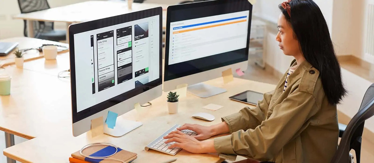 Woman typing on computer screen with designs on it