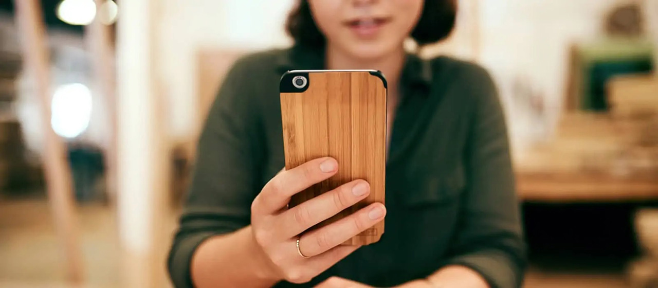 Woman holds wooden phone case