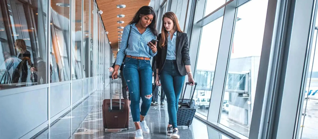 2 women walking in airport hallway