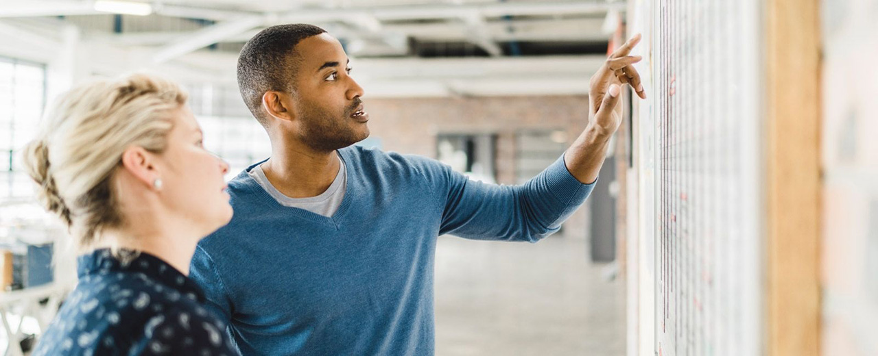 One man and woman discussing strategy in an office setting