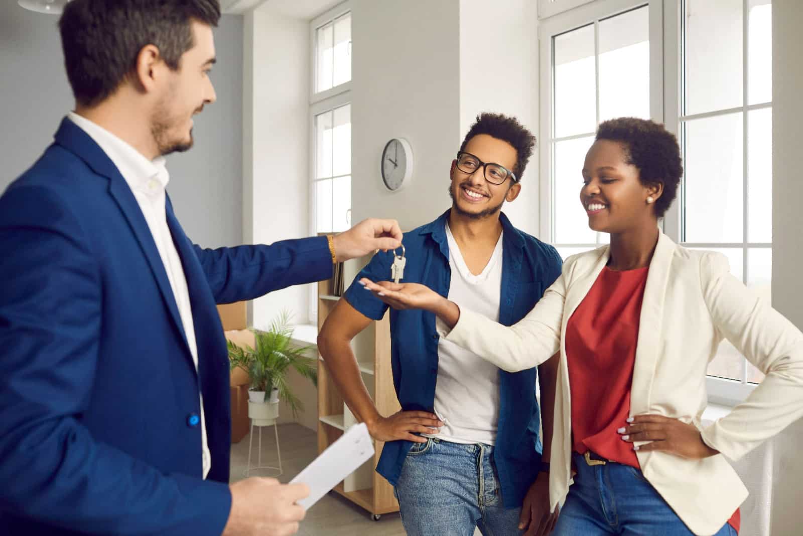 Real estate agent handing keys to young couple